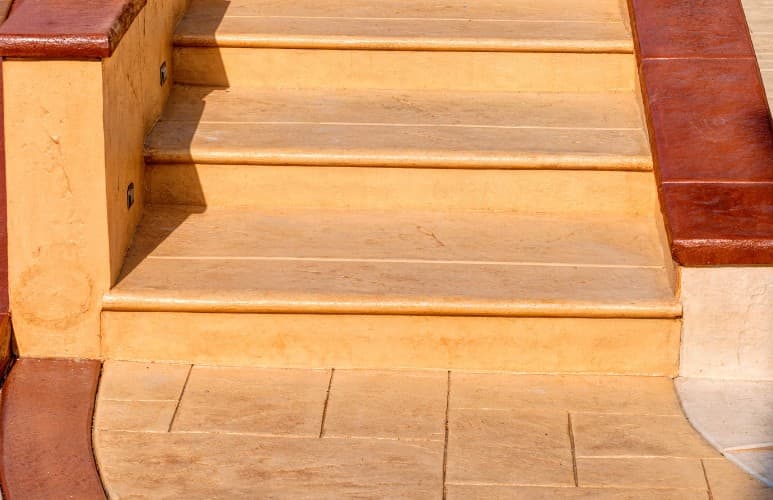 Escalera y terraza renovadas con hormigón impreso en color arena
