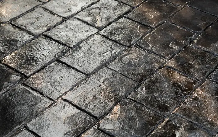 Hormigón impreso molde adoquín color antracita en el acceso de una vivienda en Punta Umbría, Huelva