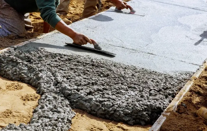 Operario fratasando hormigón impreso recién vertido durante la instalación de un pavimento en Huelva